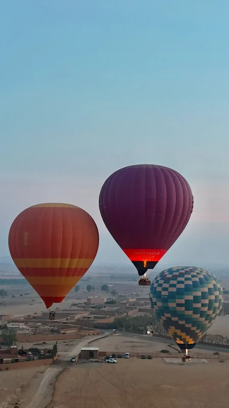 Hot air balloons rising above the Marrakech plain at dawn